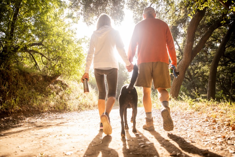 Active senior couple Walking with Dog