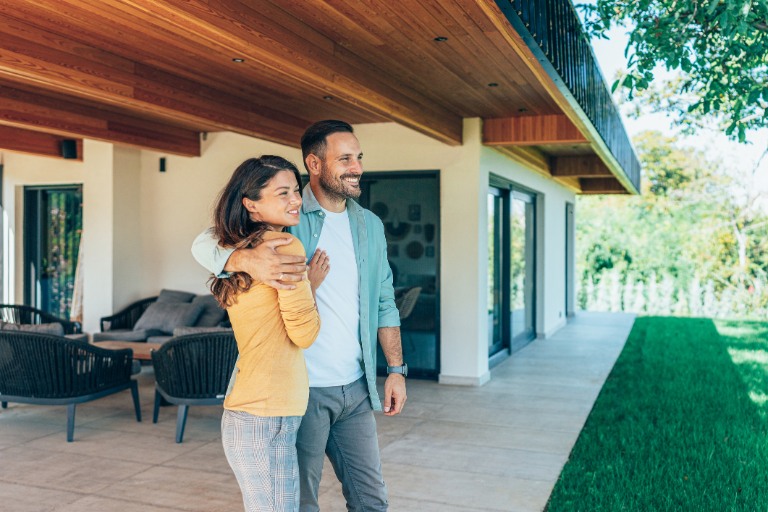 Embraced couple in front of their new house